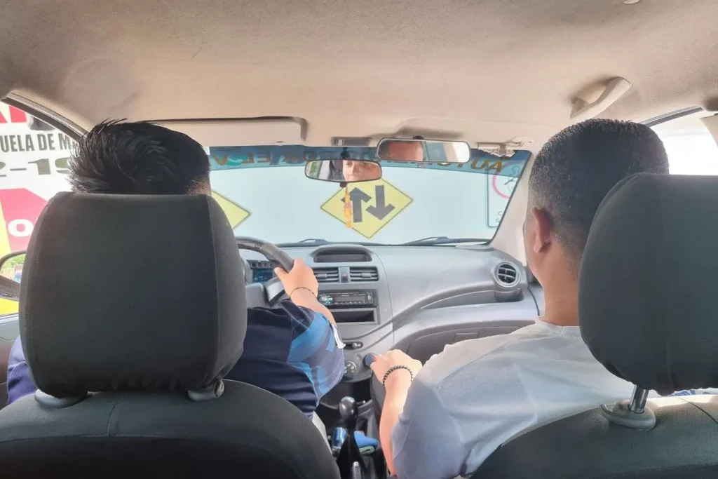 Vue intérieure d’une voiture avec conducteur et passager ceinturés, image illustrant le permis de conduire international et la mobilité transfrontalière.