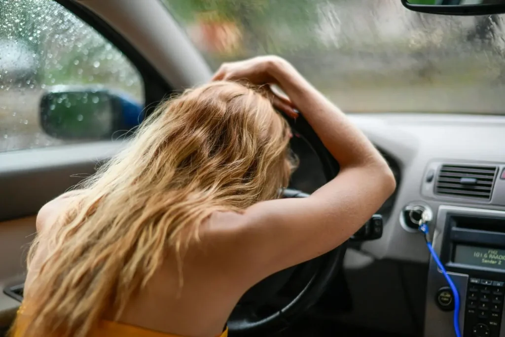 Conducteur affaissé sur le volant, image illustrant la fatigue intense et les dangers de la conduite sous vigilance réduite.