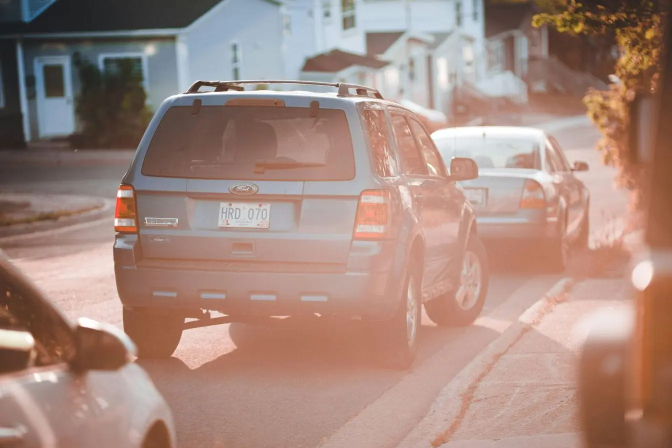 SUV bleu garé sur une rue résidentielle, image évoquant le stationnement sur trottoir qui gêne la circulation piétonne et compromet la sécurité.