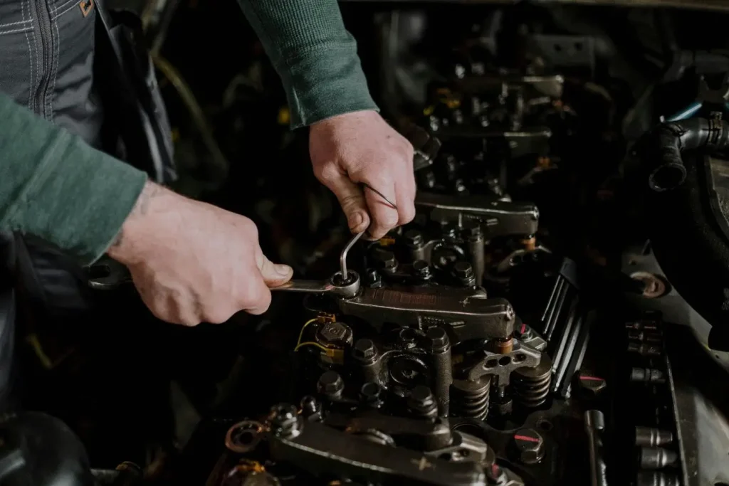 Gros plan sur mécanicien ajustant pièces moteur, scène évoquant l’entretien d’un injecteur diesel encrassé.
