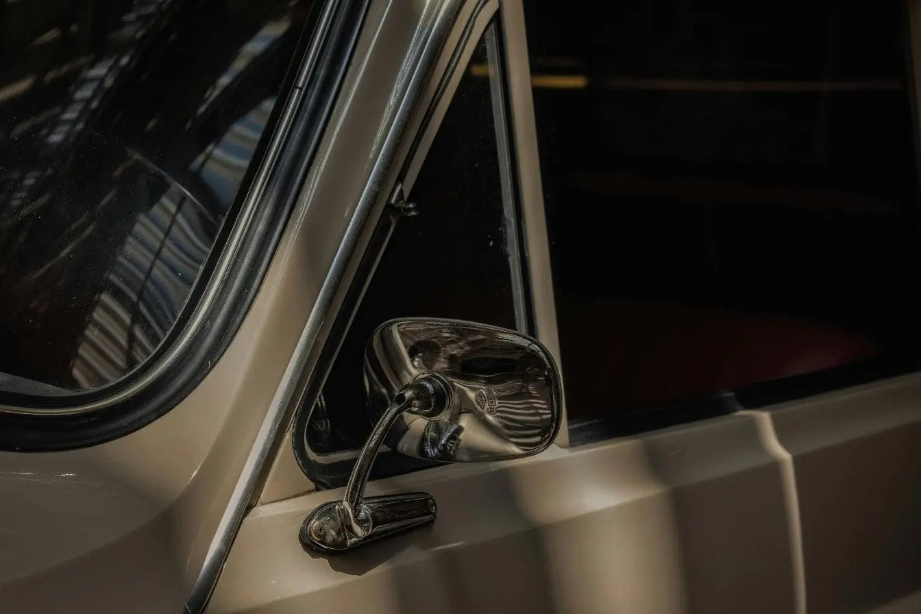 rétroviseur cassé Voiture vintage avec miroir latéral endommagé traduisant l’importance de connaître les démarches en cas de rétroviseur cassé.