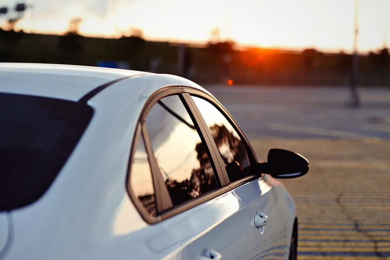 vitres teintées Voiture blanche au soleil reflétant la vigilance et la réglementation sur les vitres teintées en France.
