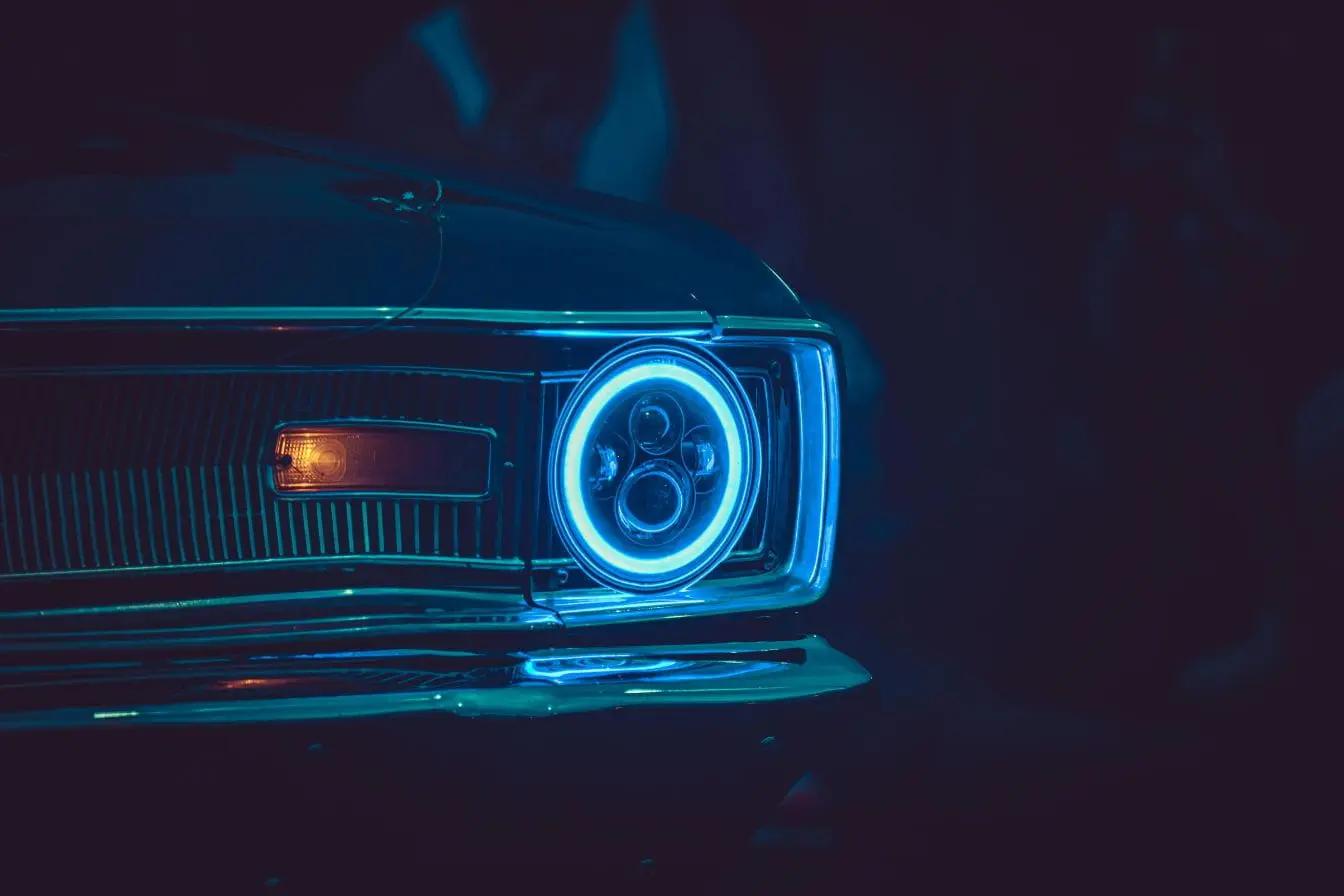 Phare bleu Anneau néon reflétant la vigilance et la précision des phares LED sur une carrosserie classique.