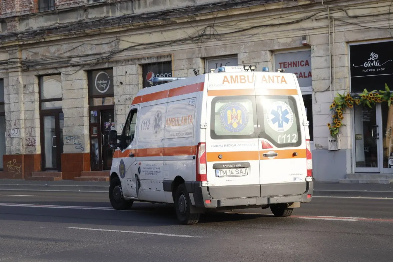 Ambulance blanche avec bandes orange circulant en ville, image qui illustre les obligations légales liées aux véhicules prioritaires.