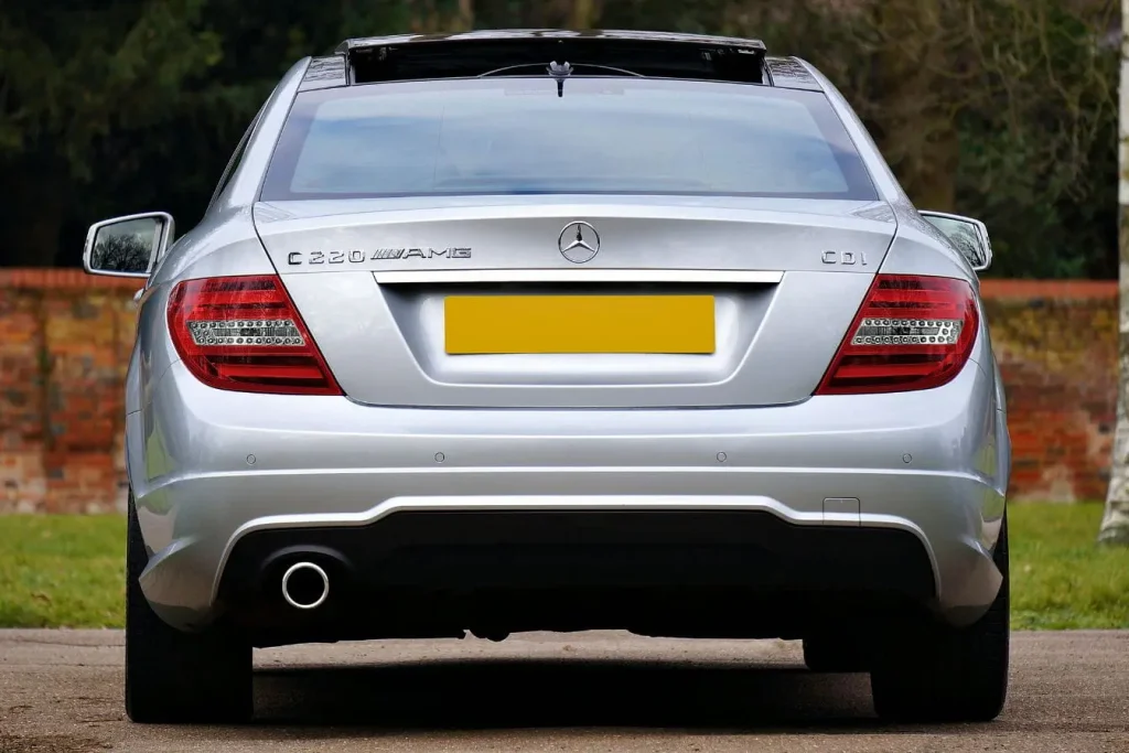 Arrière d’une Mercedes argentée garée, pot d’échappement visible, image représentative du vol de catalyseur et des solutions de sécurité.