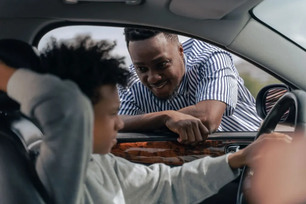 Conducteur au volant discutant avec une personne à la fenêtre, image qui illustre l’accompagnement et le coût d’une formation de moniteur auto-école.