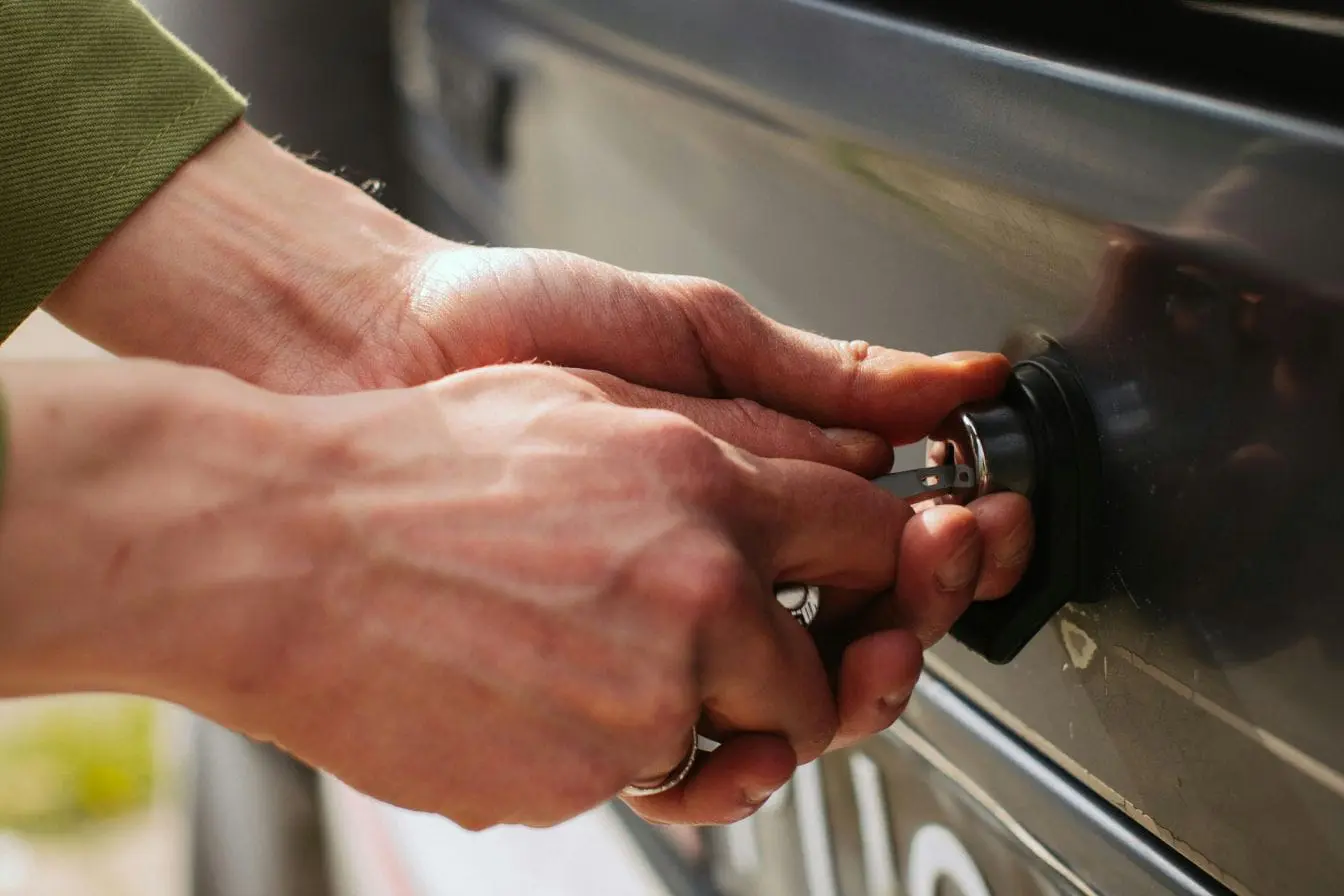 serrure de voiture Mains insèrent clé dans serrure de voiture grise, image illustrant la faille des systèmes keyless et les risques de vol automobile.