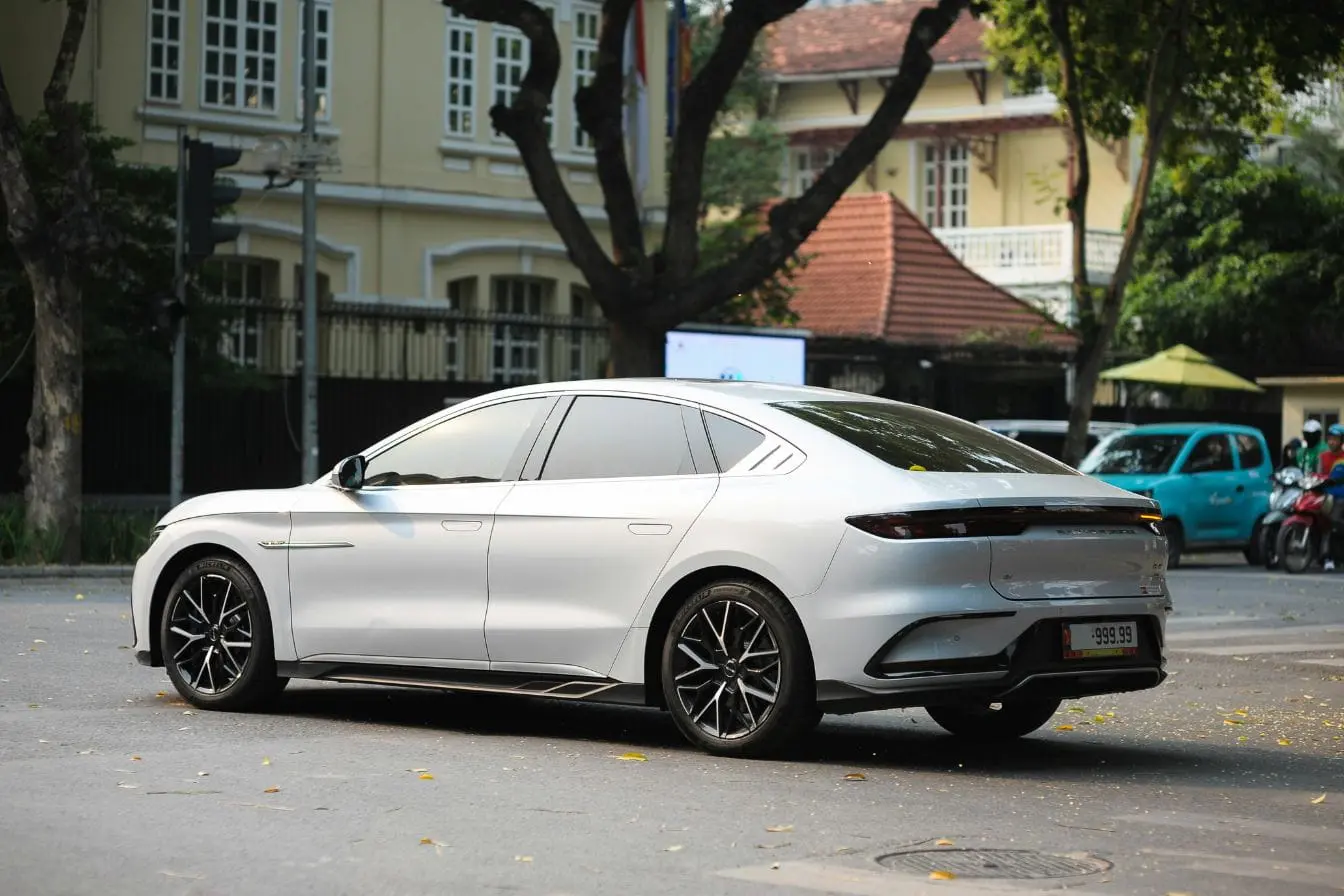 Voiture électrique au style futuriste Voiture garée devant façade classique, illustration des standards CCS et CHAdeMO.