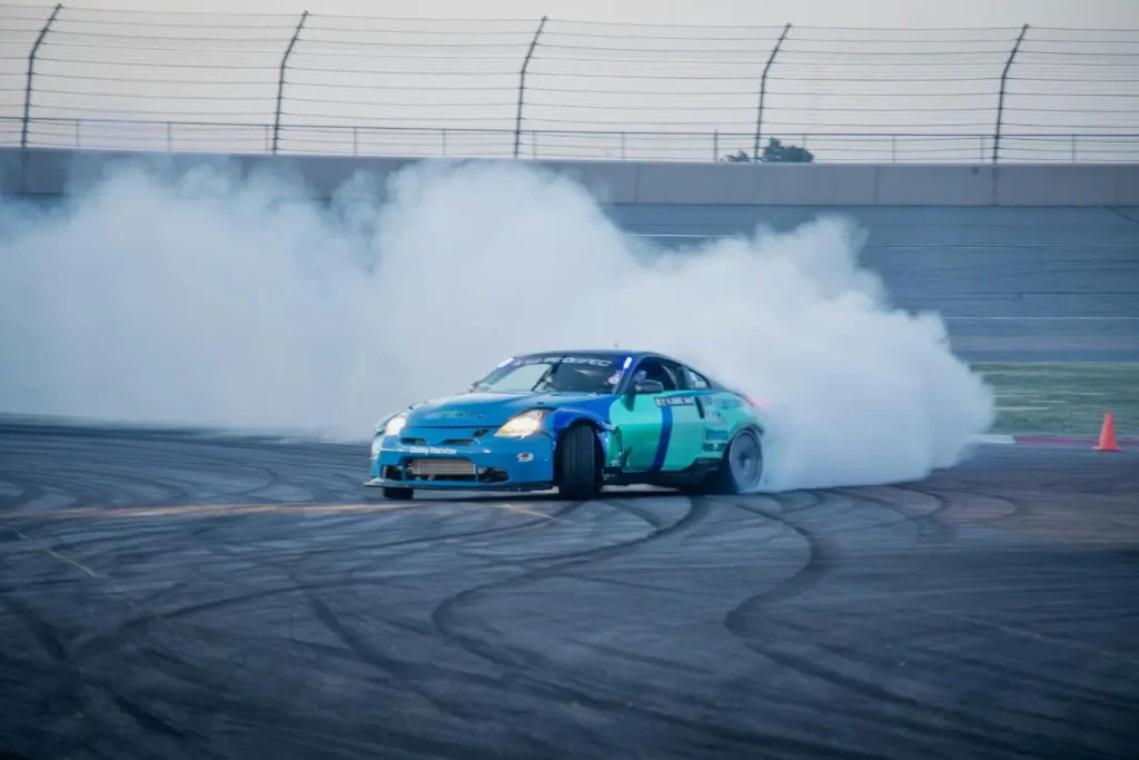 Voiture sportive bleue en plein drift avec fumée épaisse, image qui illustre les questions légales autour de la modification du pot d’échappement.