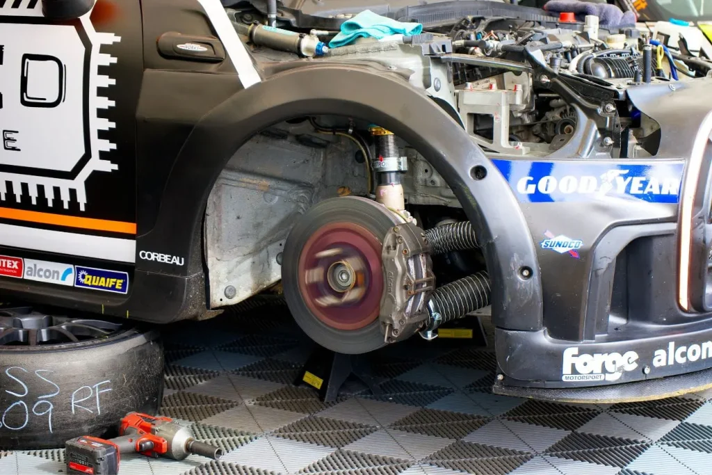 Voiture sur chandelles avec suspension exposée, symbole du kit de rabaissement et de son homologation obligatoire.