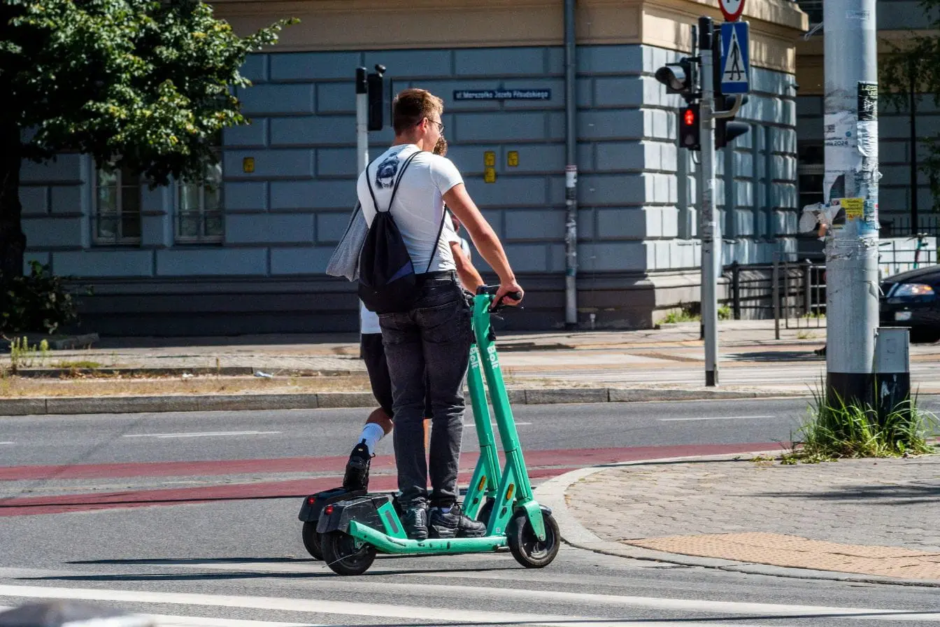 Trottinette électrique partagée traversant carrefour urbain, image claire des obligations légales sur voie publique.