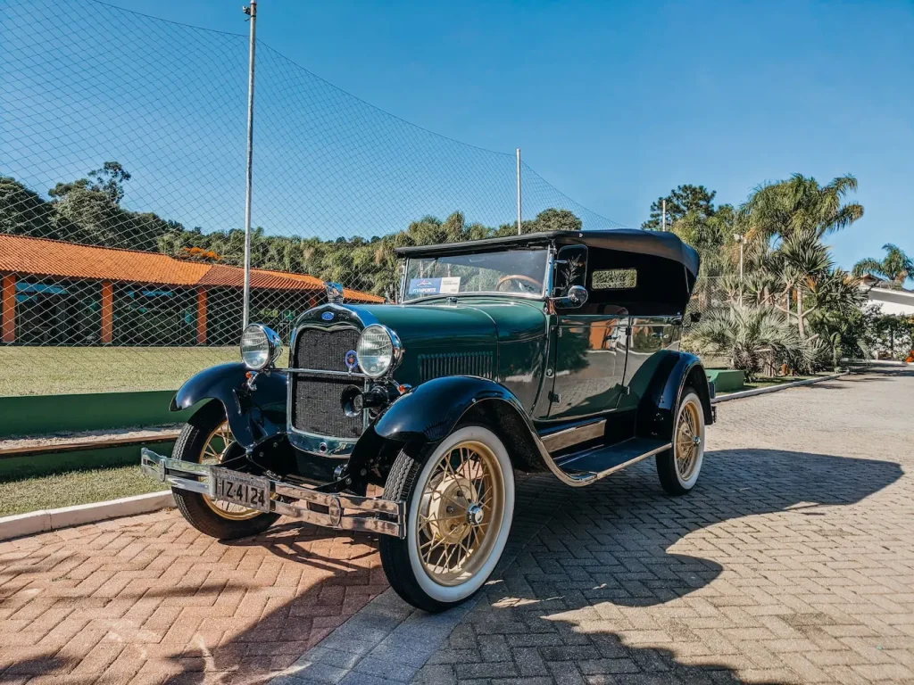 Automobile classique des années 30 stationnée dehors, reflet de l’immatriculation FFVE et de la préservation du patrimoine roulant.