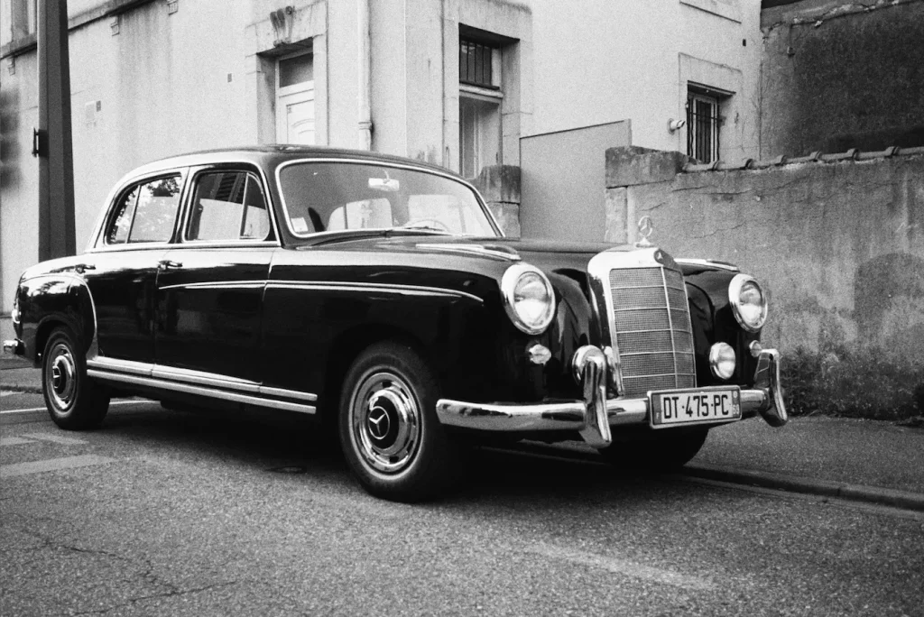 Berline vintage garée sur rue pavée, illustration du charme intemporel d’une voiture de collection.