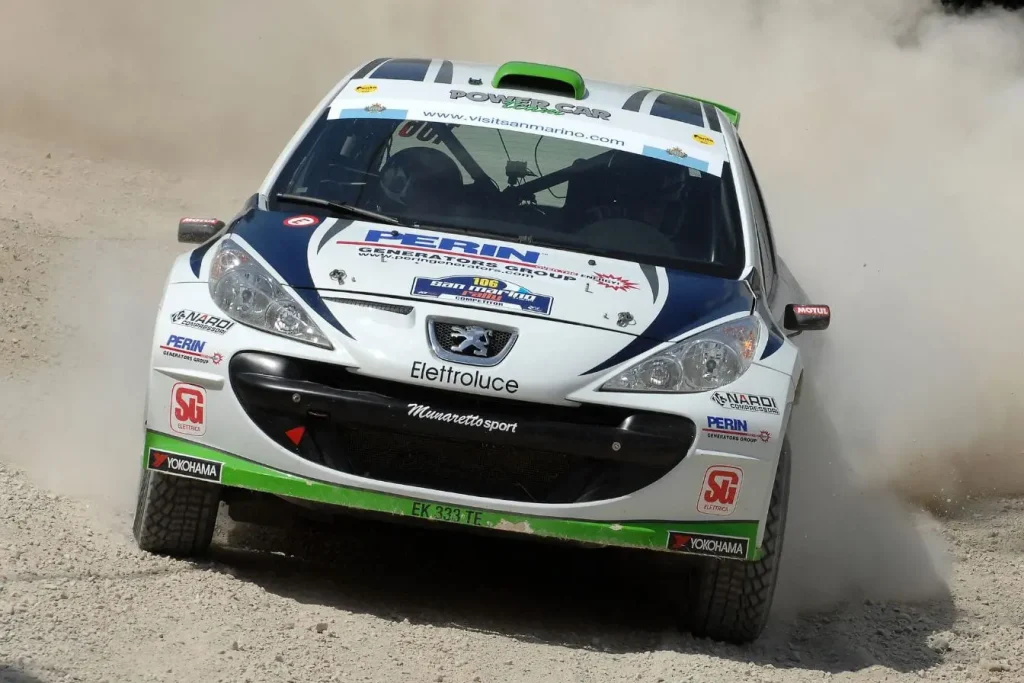 Bolide blanc, bleu et vert lancé sur piste poussiéreuse, image claire illustrant distinction entre WRC et WRC2.