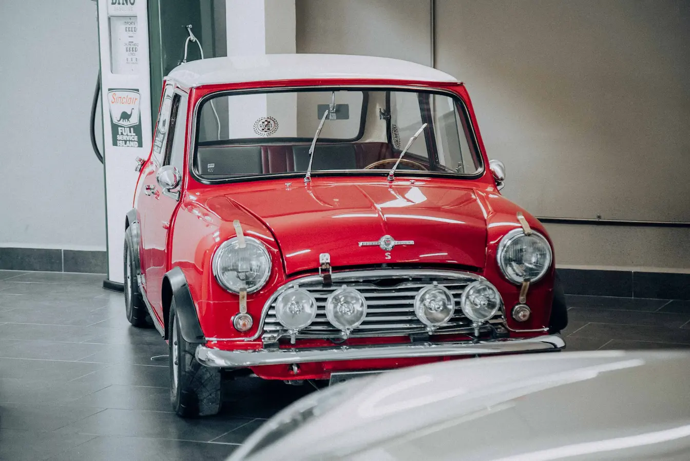 Véhicule ancien Mini Cooper rouge vintage avec toit blanc, image qui illustre véhicule ancien et carte grise collection avantages et démarches.