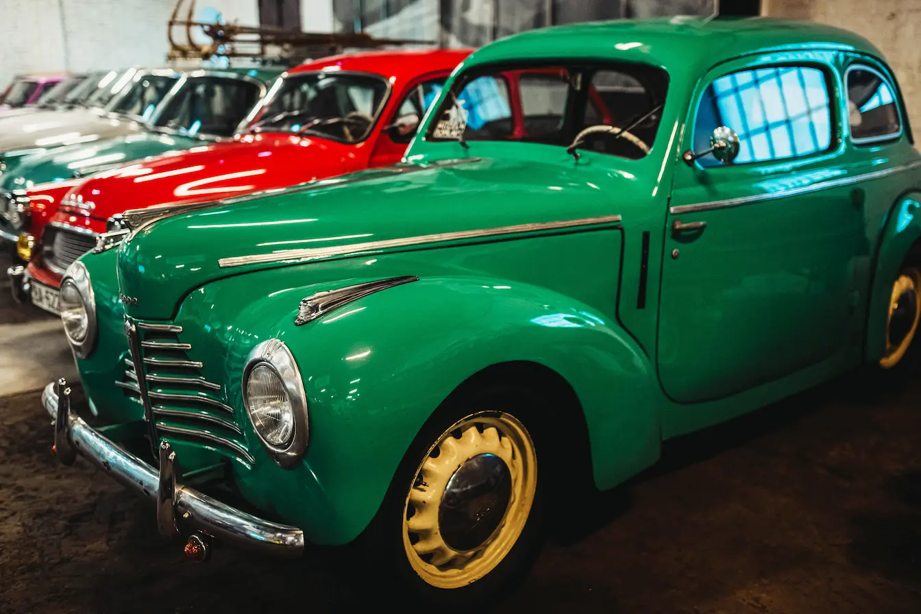 Voiture ancienne verte aux roues jaunes exposée, image qui illustre l’immatriculation FFVE et la préservation des véhicules de collection.