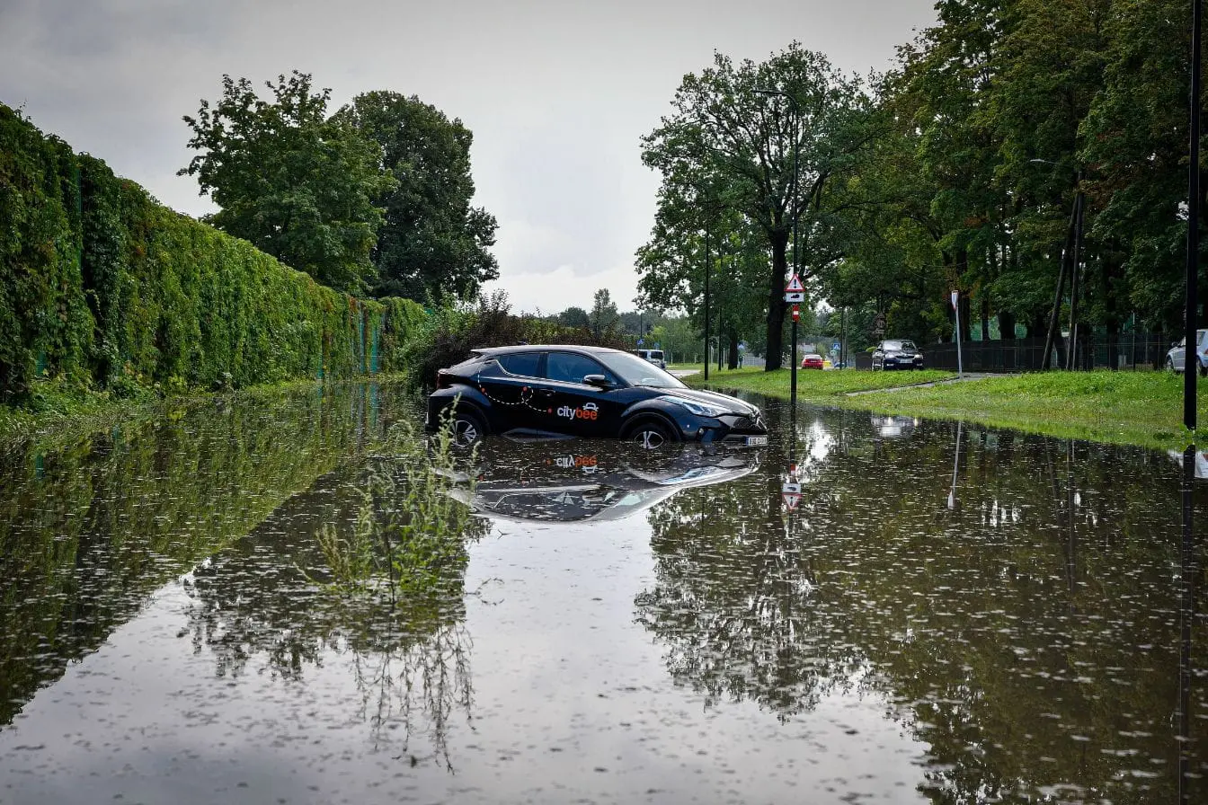 Voiture inondée Voiture noire partiellement submergée dans eau de crue, reflet des réflexes à adopter après une catastrophe naturelle.