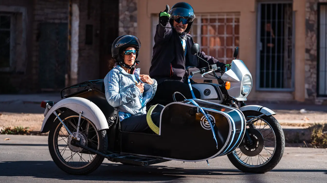Moto blanche avec side‑car noir garée devant bâtiment, image qui illustre la réglementation du permis moto side‑car.