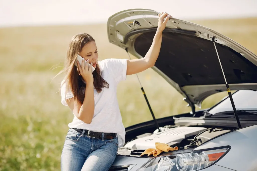 Voiture immobilisée avec chiffon jaune sur capot, illustration typique des règles de remorquage en cas de panne.