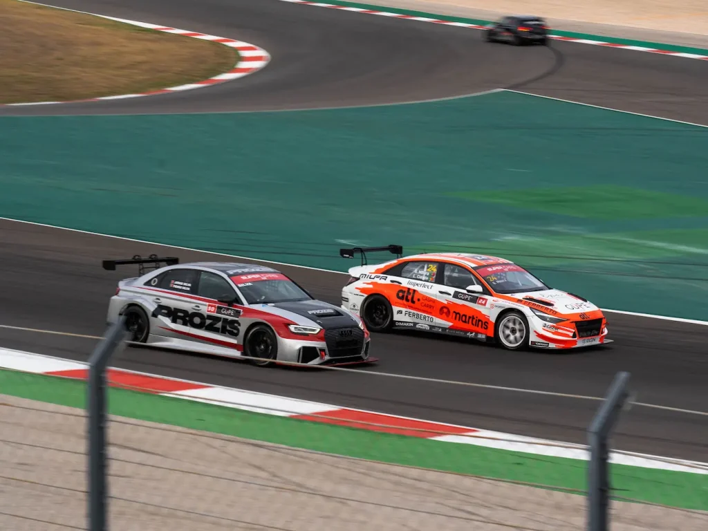 Deux voitures de course lancées sur piste professionnelle, image qui illustre le circuit automobile le plus rapide du monde.
