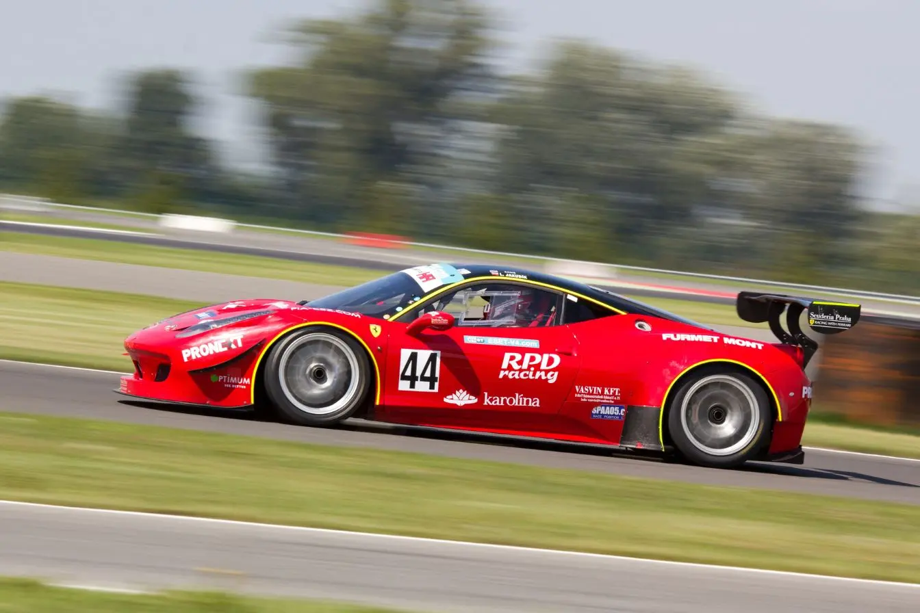 Voiture de course Voiture de course rouge lancée à haute vitesse sur un circuit, illustrant les différences de préparation, d’encadrement et de statut entre pilote officiel et pilote privé