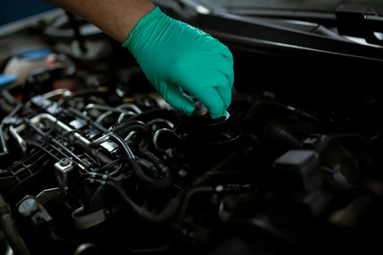 compartiment moteur Mécanicien inspectant le compartiment moteur avec un gant de protection