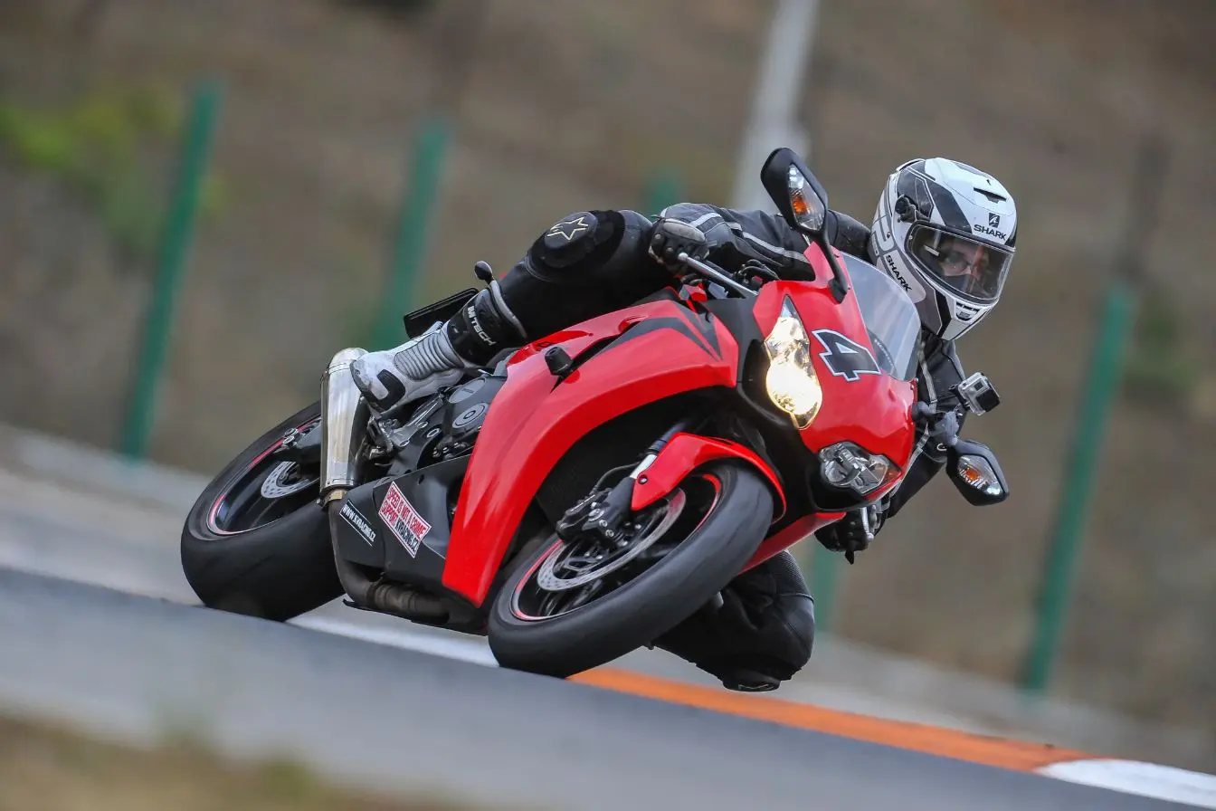 moto Moto rouge sportive penchée dans virage de circuit, symbole de vitesse extrême et des records en 2026.