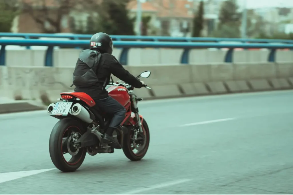 Motard circulant sur une moto au guidon relevé et à la position plus droite, illustrant les différences de confort avec une moto sportive plus radicale